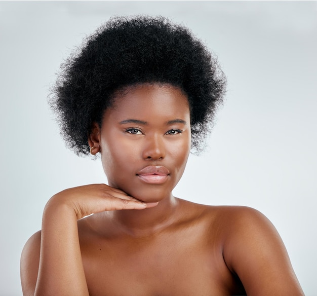 Face beauty and skincare of black woman with hand in studio isolated on a white background Portrait serious and natural model with cosmetics facial treatment or aesthetic wellness and confident