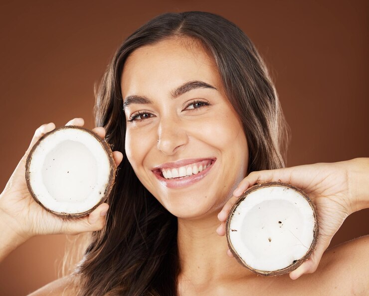 Face beauty skincare and woman with coconut in studio on a background Wellness organic cosmetics and portrait of female model with fruit product or food for healthy diet nutrients or coconut oil