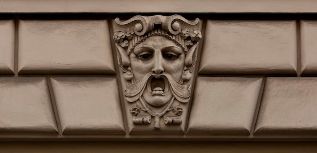 A face on a building that has a man's mouth and a beard on it.