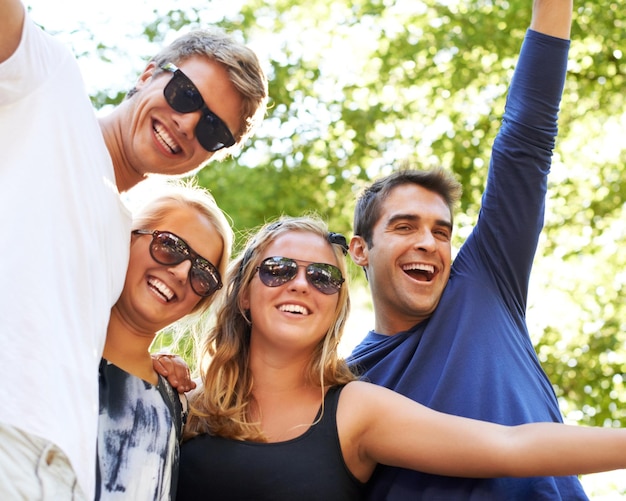 Festeggia con gli amici in un parco per un concerto di un festival musicale o una felice riunione abbraccia il divertimento e affolla le persone in una foresta con energia di libertà ed entusiasmo per la raccolta di eventi o una festa nella natura