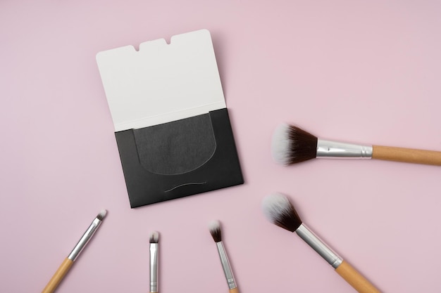 Foto face charcoal oil blotting paper met houten make-upborstels op paarse geïsoleerde achtergrond portable face wipes makeup tools schoonheidsproduct