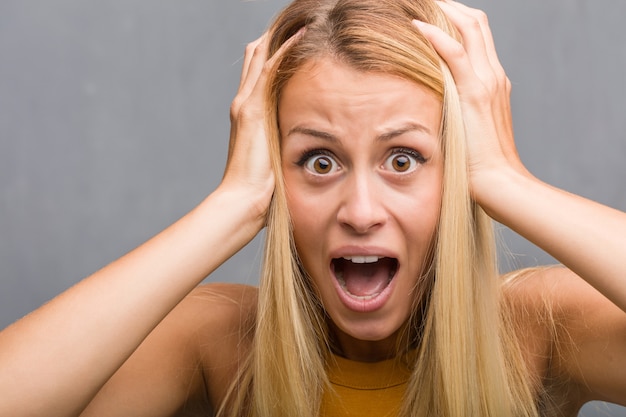 Face closeup, portrait of a natural young blonde woman frustrated and desperate