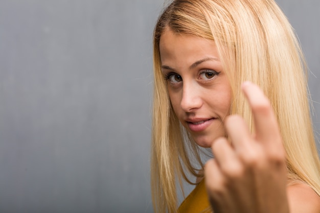 Foto affronti il primo piano, ritratto di una giovane donna bionda naturale che invita a venire