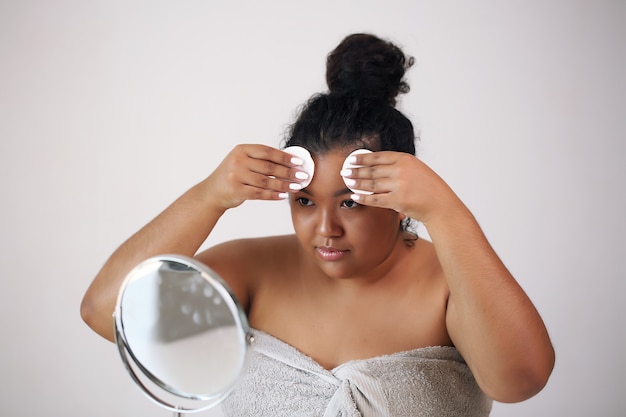 Face cream. Young beautiful woman in a white towel,