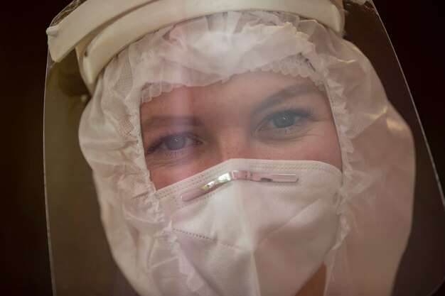 The face of a female doctor closeup in a protective suit