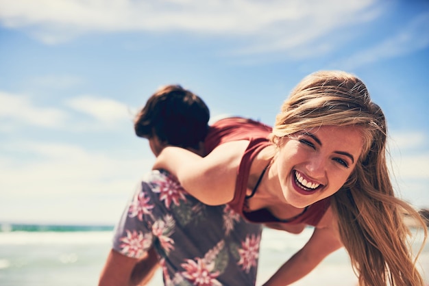 The face of fun Portrait of an attractive young woman being carried by her boyfriend on the beach