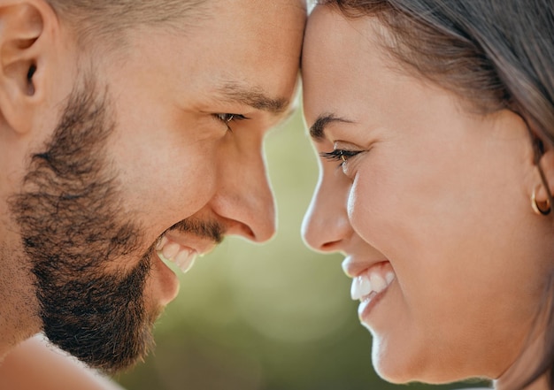 Face of happy couple touching head in love care and happiness in garden park or spring nature outdoors Closeup young smile and happy people man and woman relax together on romantic summer date