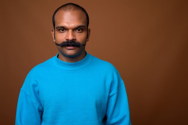 Face of Indian man with mustache wearing blue sweater