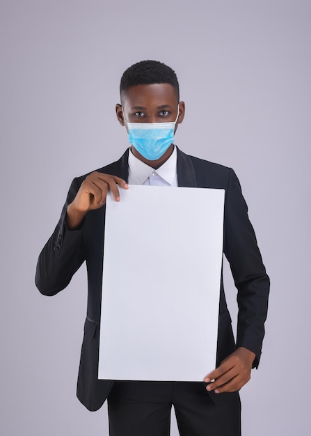 face mask carrying white board sign African Covid19 concept - close-up portrait of a young man