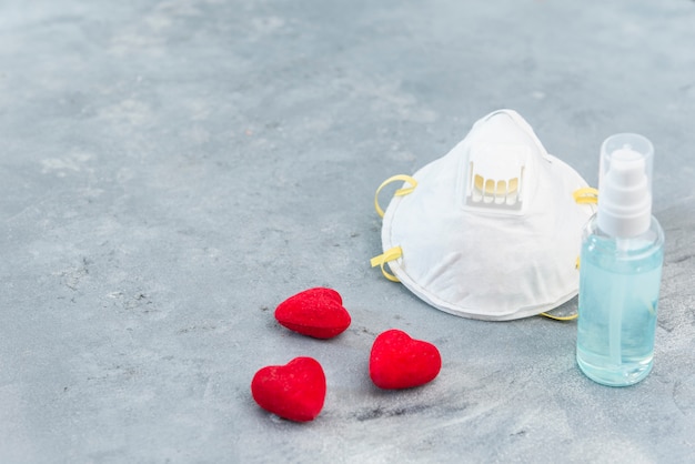 Face mask and hand gel on concrete background