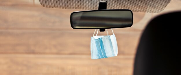 Face mask hanging on the rearview mirror in the car