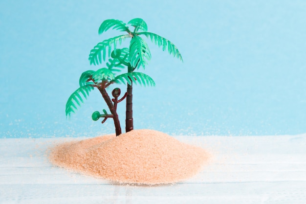 フェイスマスクプラスチック製のヤシの木と青い背景の上の砂