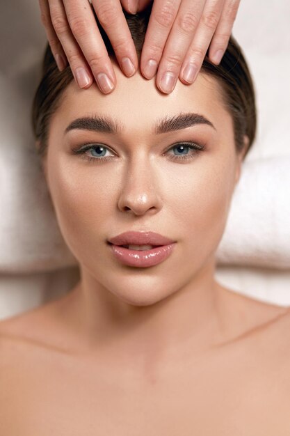 Face massage Closeup of young woman getting spa massage treatment at beauty spa salon