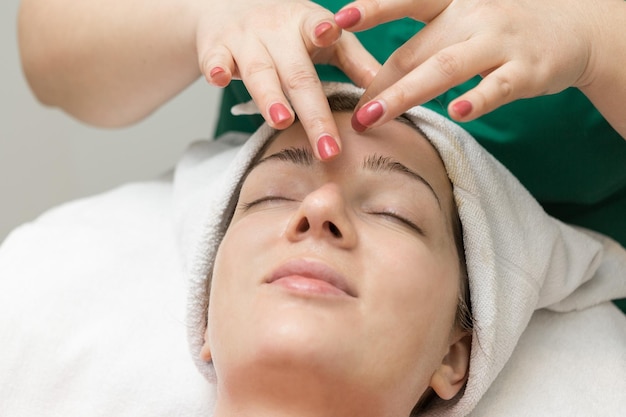 Face massage Young woman getting spa massage treatment at beauty spa salon Spa skin care Cosmetology