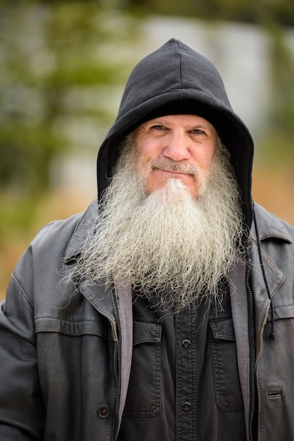 Face of mature bearded hipster man wearing hood