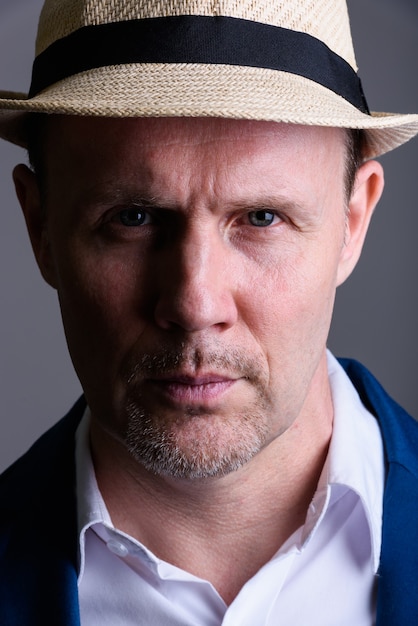 Face of mature businessman wearing hat indoors