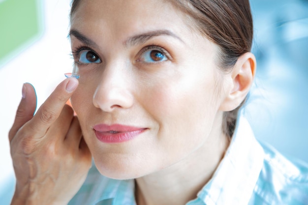 Face of a nice positive woman smiling while wearing eye lenses