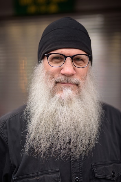 Фото Лицо зрелого красивого бородатого мужчины в очках на улице на улице