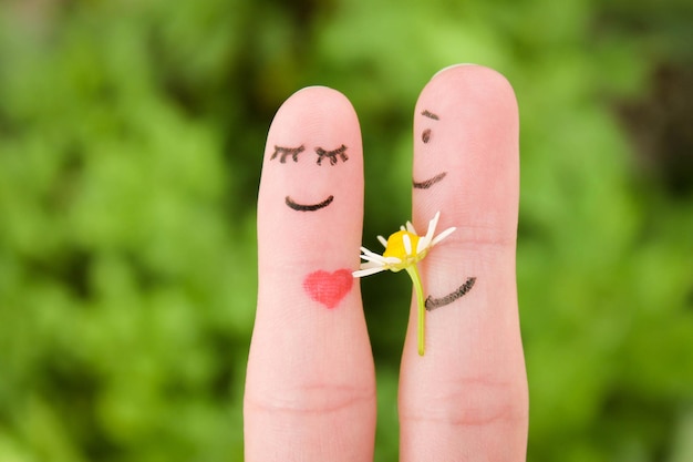 Face painted on fingers Man is giving flowers to a woman