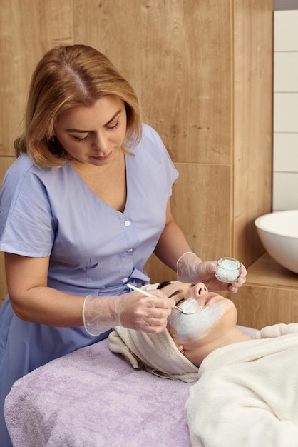 Face peeling mask spa beauty treatment skincare Woman getting facial care by beautician at spa salon