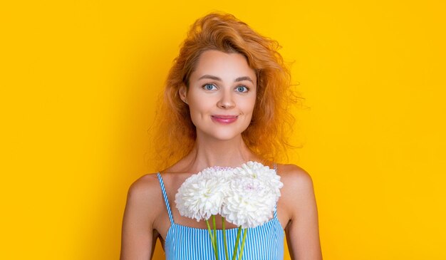 Face photo of girl with mothers day chrysanthemum flowers girl with mothers day flowers isolated on yellow girl with mothers day flowers in studio girl with mothers day flowers on background