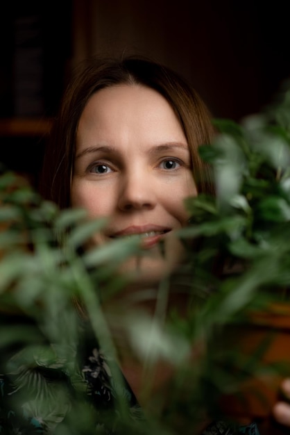 Портрет лица женщины средних лет в зеленых растениях, улыбающаяся женщина в сорокалетнем возрасте Расслабленное спокойное состояние счастливое лицо