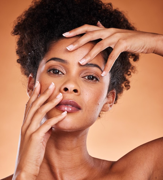 Face portrait skincare and beauty of black woman in studio isolated on an orange background Makeup luxury cosmetics and female from South Africa touching skin for facial wellness and healthy skin