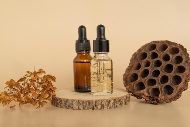 A face serum or essential oil with golden parts standing on a wooden plate