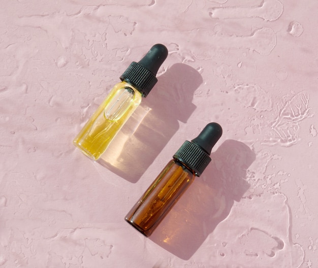 Face serum and leaves on pink