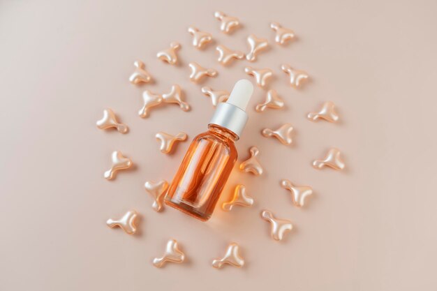 A face serum in pink capsules in the form of heart and a face\
serum or natural oil lying on a pink background