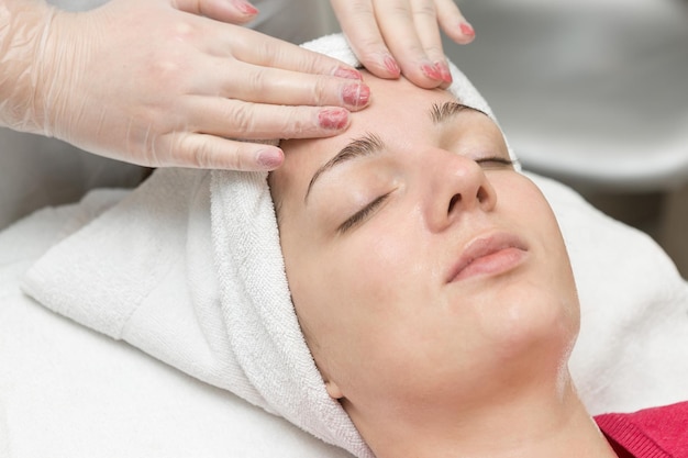 Face skin care Beautician applying beauty oil mask on face using brush In spa salon