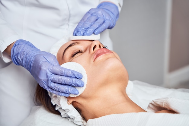 Photo face skin care. close-up of woman getting facial hydro microdermabrasion peeling treatment at cosmetic beauty spa clinic. hydra vacuum cleaner. exfoliation, rejuvenation and hydration. cosmetology.