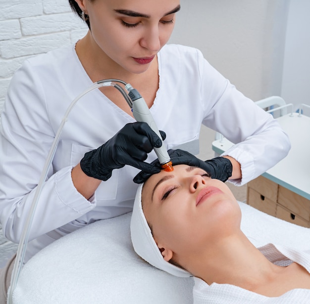 Face Skin Care. Closeup Of Woman Face Cleansing At Cosmetology clinic, vacuum cleaning