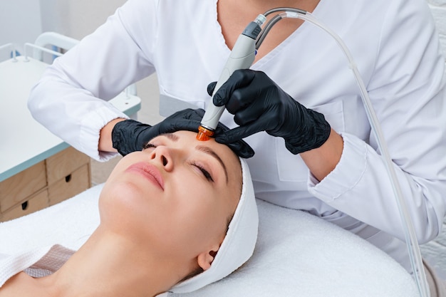 Face Skin Care. Closeup Of Woman Face Cleansing At Cosmetology clinic, vacuum cleaning