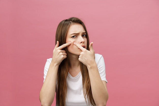 Foto problema di pelle del viso - giovane donna infelice tocca la sua pelle