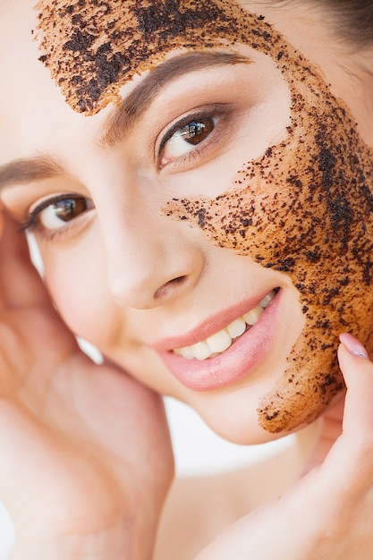 Face Skincare. Young Charming Girl Makes a Black Charcoal Mask on Her Face