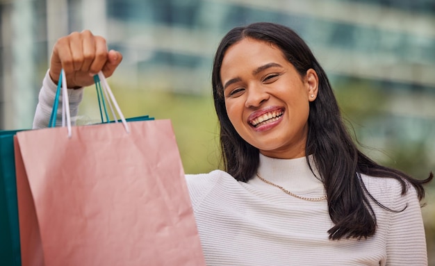 face smile and woman with shopping bags in city after shopping at retail shop store or mall for clothing sale portrait fashion and young female from india happy with sales purchase from boutique