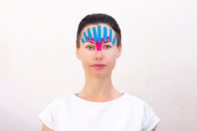 Face taping, close-up of a girls face with cosmetological anti-wrinkle tape. Face aesthetic taping. Non-invasive anti-aging lifting method for reduction of wrinkles