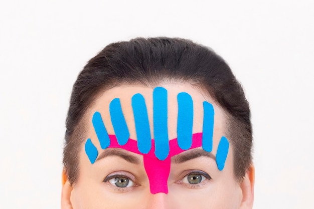 Face taping, close-up van het gezicht van een meisje met cosmetologische anti-rimpel tape. Gezicht esthetische taping. Niet-invasieve anti-aging liftmethode voor het verminderen van rimpels