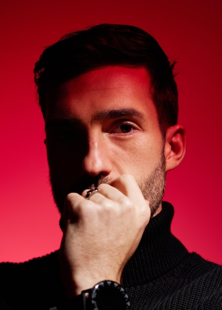 Face thinking and red with a man model in studio on a color wall background for idea or contemplation Fashion portrait and creative with a handsome young male posing against a red background alone