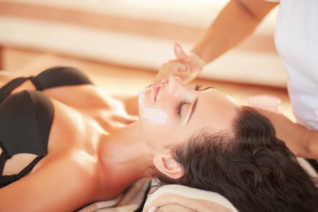 Face Treatment. Woman in Beauty Salon Gets Marine Mask