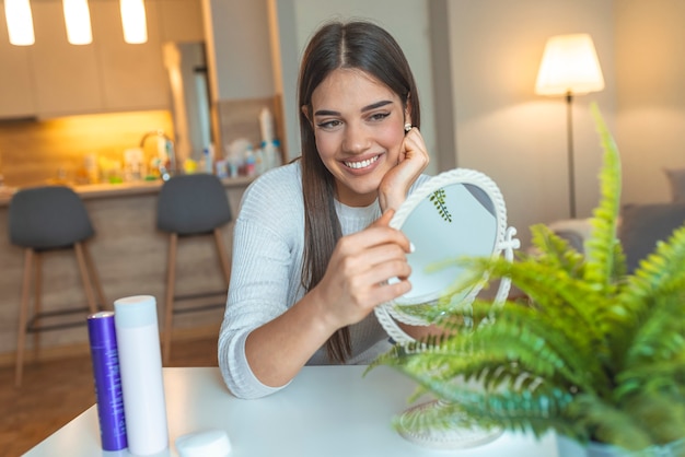 Photo face of young beautiful healthy woman looking in the mirror.