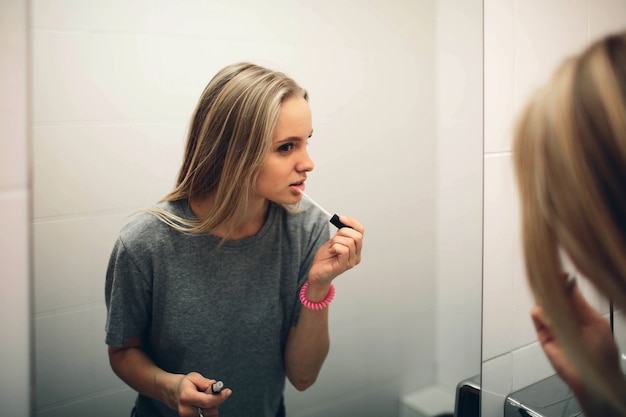 Face of young beautiful healthy woman and reflection in the mirror