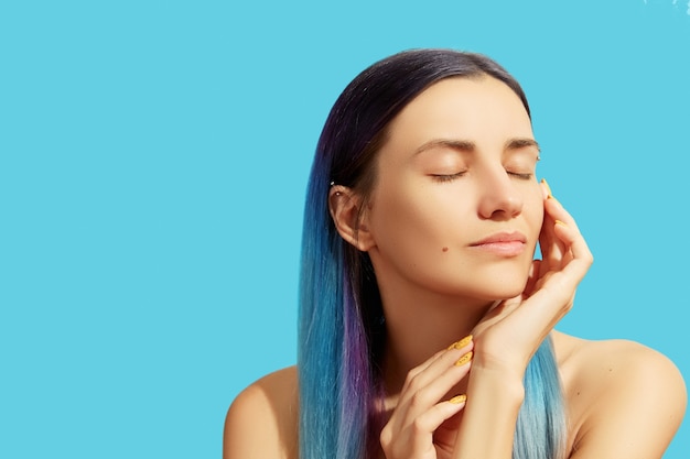 Face of young beautiful woman with blue hair 