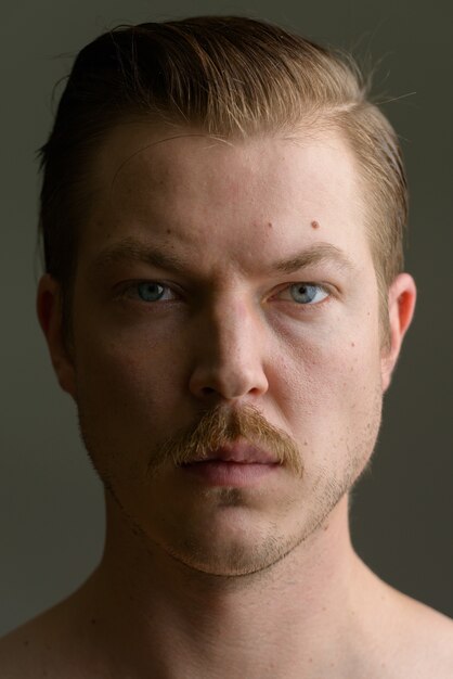 Face of Young Caucasian man shirtless looking at camera