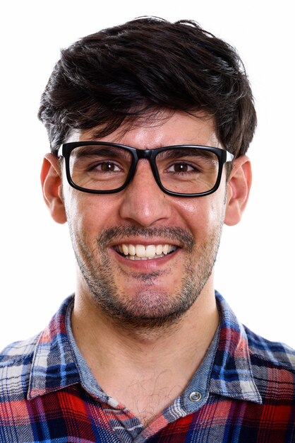 Face of young happy Persian man smiling while wearing eyeglasses