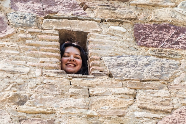 고대 돌담의 오목한 곳에 있는 젊은 여성의 얼굴