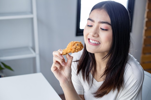 Face of young woman was happy to eat the delicious fried chicken. fried chicken drumstick