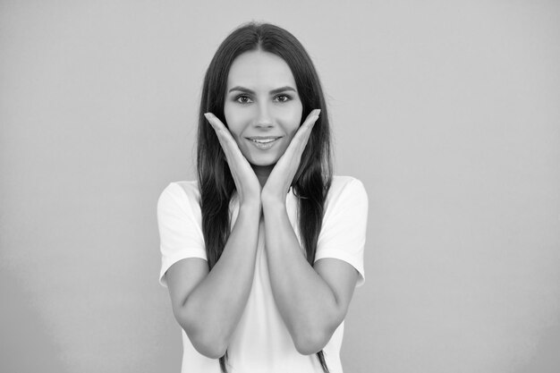 Face of young woman in white shirt on blue background