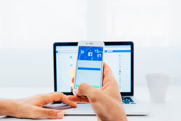 Фотография facebook на телефоне и ноутбуке
